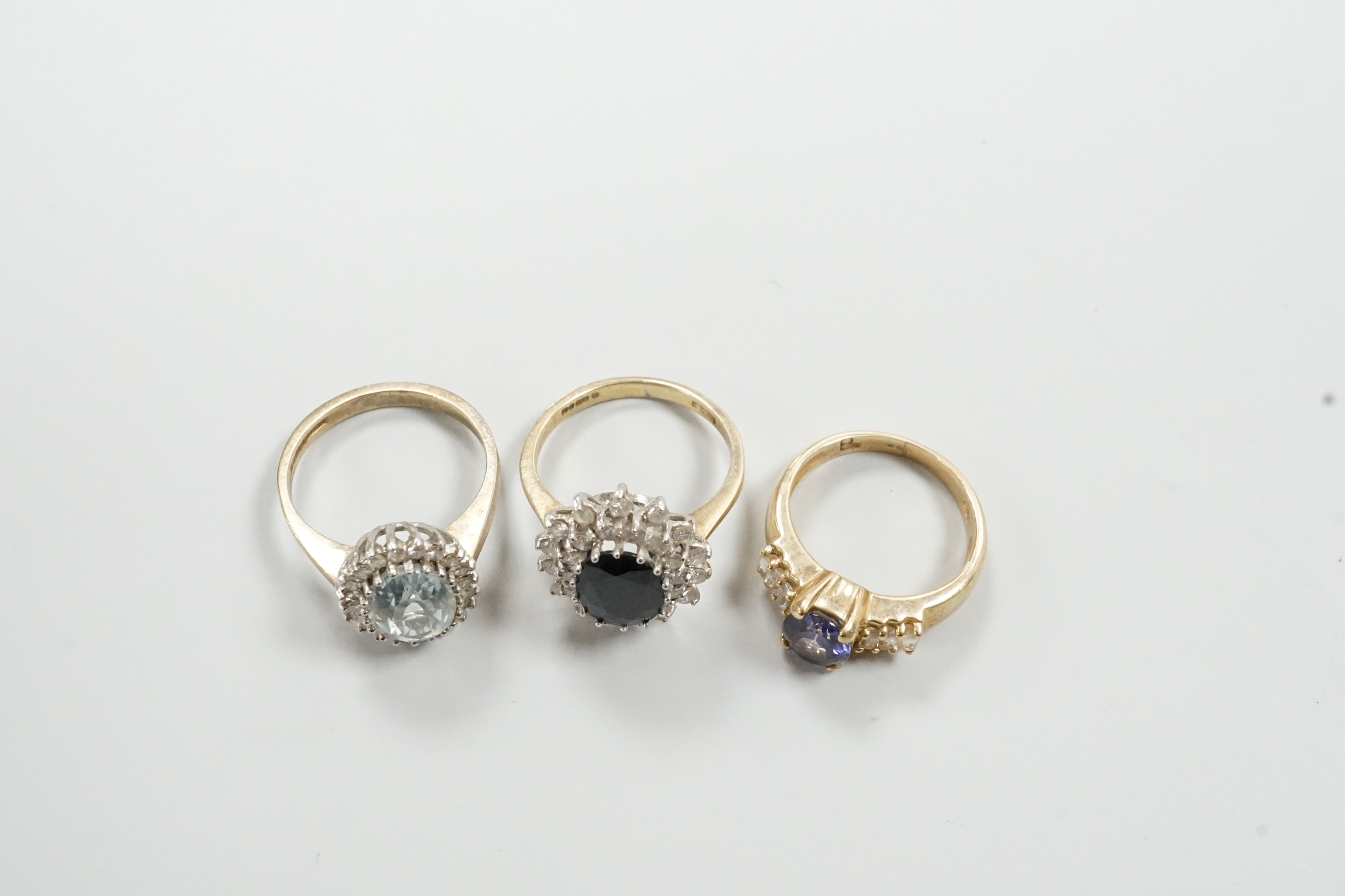 Three assorted modern 9ct gold and gem set dress rings, including sapphire and diamond chip set oval cluster, size K/L, gross weight 9.6 grams.